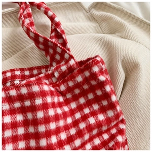 Detailed close-up of red and white checkered canvas tote bag with soft fabric texture