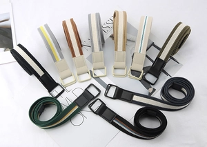 Detail of striped canvas belts with double ring buckles in black, khaki, and gray tones