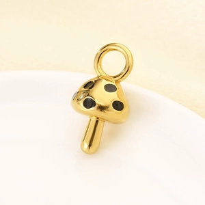 Macro shot of gold-plated stainless steel mushroom pendant with black enamel dots
