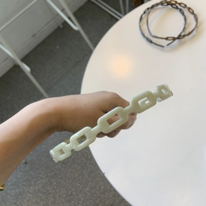 Detail of cream acetate chain headband featuring a retro linked chunky design for women