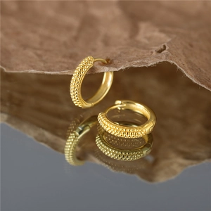 Golden S925 sterling silver hoop earrings with beaded texture on brown pleated paper