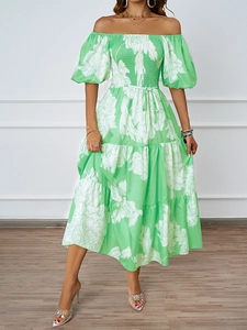 Détail d'une robe fleurie verte élégante avec épaules dénudées et des manches bouffantes