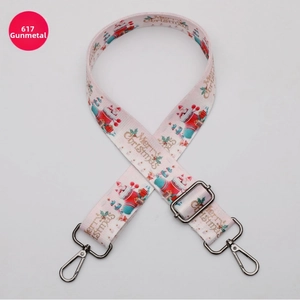 Detail of Christmas themed pink shoulder strap with gunmetal swivel hooks and adjustment buckle