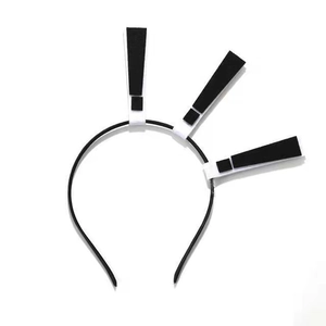 Detail view of a black Halloween headband featuring three black and white exclamation marks