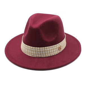 Detail of burgundy wool fedora with plaid band and gold M metal buckle accent
