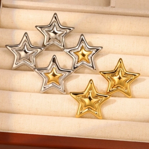 Polished 18K gold and silver plated layered star earrings on a beige jewelry tray