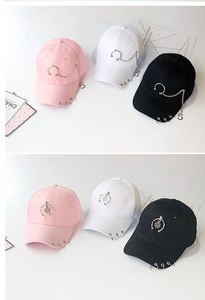 Detail of cotton baseball caps with metal rings and chains in pink, white and black colors