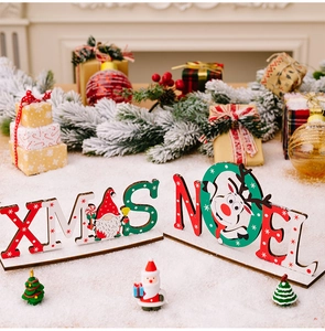 Dettaglio dei cartelli in legno XMAS e NOEL con decorazioni di gnomi e renne natalizie