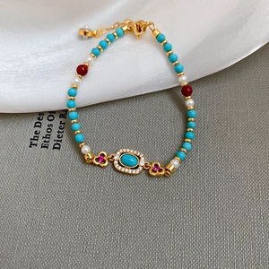 Detail of vintage beaded bracelet with pearls, turquoise, and gold center stone