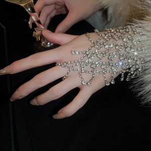 Detailed view of luxury silver rhinestone mesh hand chain with fringe finger ring