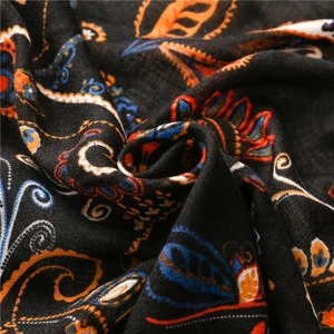 Macro shot of paisley print pattern on soft black cotton-linen texture ethnic shawl
