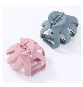 Dettaglio di grandi pinze per capelli in acrilico opaco, rosa pastello e grigio blu