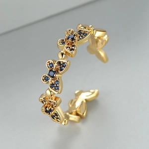 Detail of gold butterfly ring with blue zircon micro-pave on adjustable open band