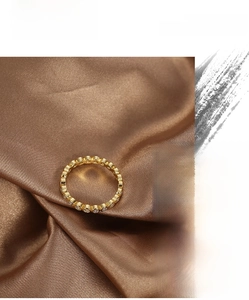 Detailed close-up of a gold-plated eternity band with micro-pave white zircon stones