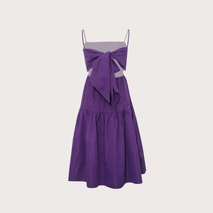 Détail d'une robe maxi bohème violette avec décolleté à nœud et jupe plissée