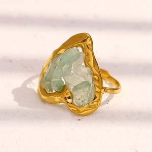 Macro shot of heart-shaped ring with green tiger eye stones and hammered gold texture
