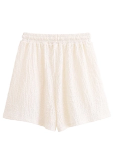 Detail of white textured seersucker fabric shorts featuring an elastic waistband for comfort