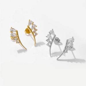 Detailed view of leaf-shaped S925 silver stud earrings in gold and silver with clear gems
