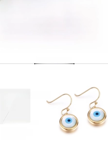 Détail de boucles d'oreilles œil maléfique en acier 316L doré avec charms bleus durables