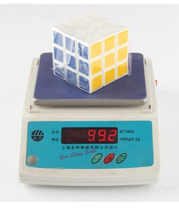Detailed weighing of a smooth 3x3 speed cube on a scale showing 99.2g mass
