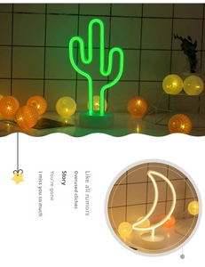 Macro detail of LED cactus and moon neon lights with circular decorative base