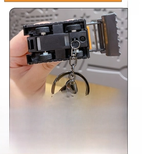 Detailed bottom view of mini alloy excavator keychain with pull-back wheel mechanism
