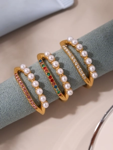Vue détaillée d'une bague triple en or ornée de perles blanches et zircons colorés