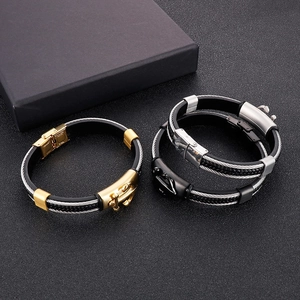 Dettaglio dei bracciali in corda d'acciaio con chiusure ad ancora in oro, argento e nero