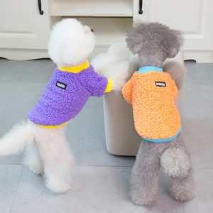 Detail of plush fleece dog sweaters in purple and orange showing soft texture and cozy fit