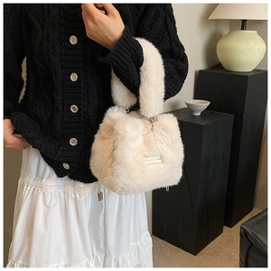 Detail of plush off-white bucket bag featuring drawstring and love every day tag