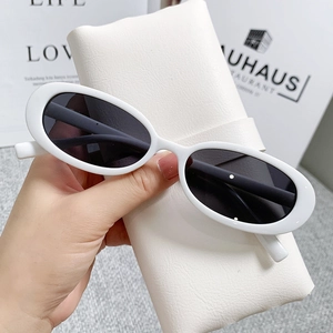 Close-up of white oval frame sunglasses with a stylish leather storage pouch
