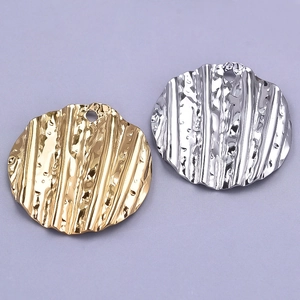 Detailed macro view of gold and silver plated 304 stainless steel pleated round pendants