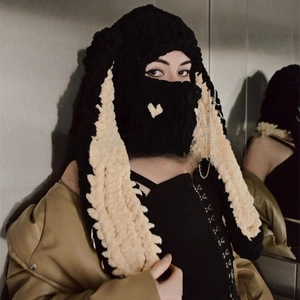 Detail of knitted bunny ear balaclava with heart embroidery and metal chain décor