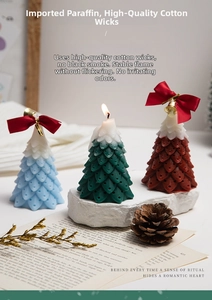 Detailed view of handmade Christmas tree scented candles with bows and golden bells