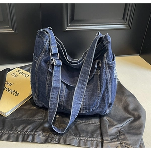 Détail du sac cabas en denim délavé bleu avec poches et boucle métallique réglable