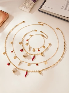 Détail du collier et du bracelet en acier doré avec des breloques en zircone 5A