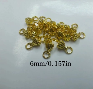 Detail shot of 6mm gold-plated lotus flower jewelry pendants showing size and texture