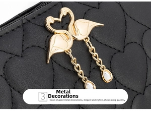 Detail of golden swan hardware and heart-shaped quilting on black leather bag