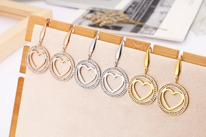 Detailed view of heart-shaped hollow earrings with crystals in gold, silver, and rose gold