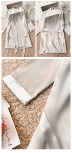 Detail view of pearl white satin bathrobe showing smooth texture and belted waist