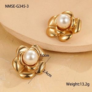 Macro view of golden camellia flower earrings with center pearl on a stone base