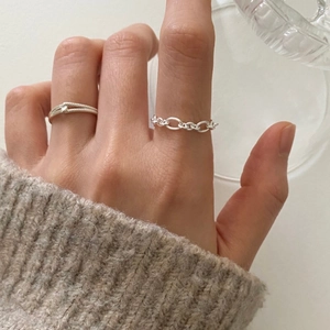 Detailed view of 925 sterling silver minimalist band and chain link rings on finger