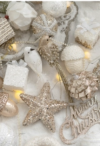 Macro view of white and gold Christmas tree ornaments with glitter and sequins in fake snow