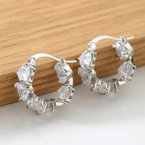 Macro shot of silver S925 huggie hoop earrings with pear-cut cubic zirconia stones