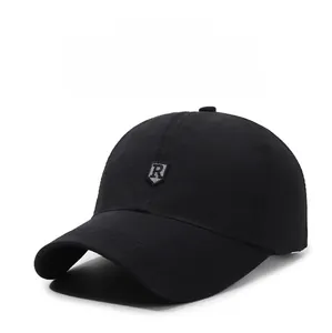Detail of a black baseball cap featuring a silver shield-shaped R logo on the front