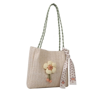 Straw tote bag with floral accents and silk scarf featuring woven green shoulder straps
