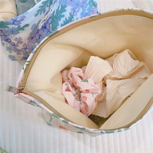 Macro detail of floral canvas makeup bag showing large capacity and zipper closure