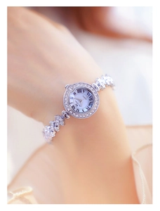 Detail of luxury silver women's watch with rhinestone bracelet and Roman numeral dial
