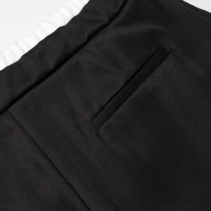 Detailansicht des elastischen Bundes und der Paspeltasche an der schwarzen Hose