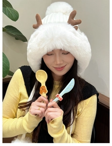 Detail of white plush trapper hat with cute reindeer antlers and soft faux fur texture